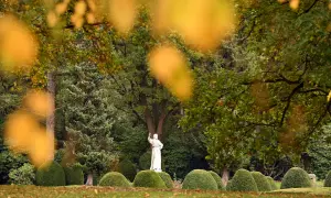 Kamienna postać w otoczeniu bujnej zieleni i jesiennych liści. To miejsce, choć spokojne, skrywa historię największego cmentarza w Europie.