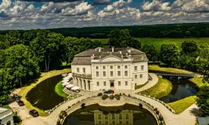 Pałac w Kurozwękach, otoczony fosą i parkiem, to wspaniałe atrakcje. Widać mostki, stawy i otaczający las.
