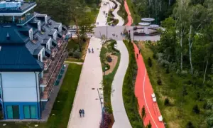 Nowoczesny deptak w Świnoujściu z hotelami i ścieżkami rowerowymi w otoczeniu zieleni.