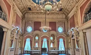 Wnętrze pałacu poznańskiego z bogatymi zdobieniami, wielkimi oknami i dwoma żyrandolami.