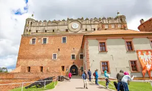 Zamek Golubski, jedna z głównych atrakcji Golubia-Dobrzynia, z turystami zwiedzającymi dziedziniec.