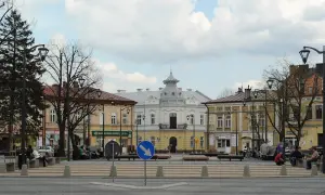 Rynek w Mielcu z kamienicami i ludźmi odpoczywającymi na ławkach. Idealne miejsce na mielec atrakcje na weekend.