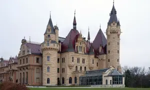 Imponujący zamek z licznymi wieżami i czerwonymi dachami, jeden z wielu pięknych zamków w Polsce.