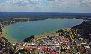 Okuninka: mnóstwo ludzi na plaży i w wodzie, karuzele i inne atrakcje dla dzieci.