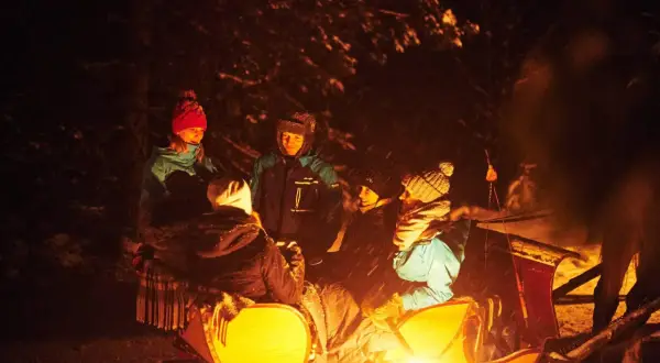 Zakopane kulig z ogniskiem: grupa przyjaciół w saniach, rozgrzewa się przy ognisku. Cena tej zimowej atrakcji jest przystępna.