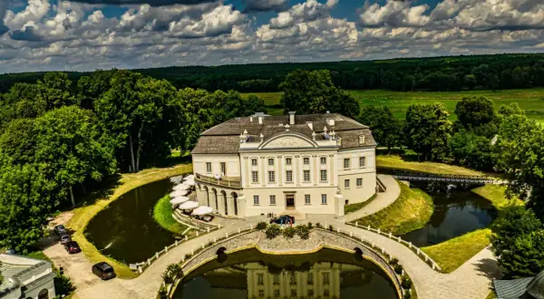 Pałac w Kurozwękach, otoczony fosą i parkiem, to wspaniałe atrakcje. Widać mostki, stawy i otaczający las.