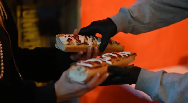 Pyszne hot-dogi z sosem i posypką na nocnym targu w Warszawie.