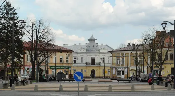 Rynek w Mielcu z kamienicami i ludźmi odpoczywającymi na ławkach. Idealne miejsce na mielec atrakcje na weekend.