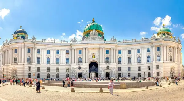 Wiedeński pałac Sisi, Hofburg, z zieloną kopułą i tłumem turystów na placu.