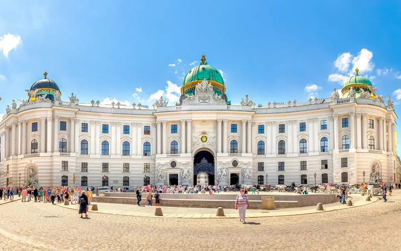 Wiedeński pałac Sisi, Hofburg, z zieloną kopułą i tłumem turystów na placu.