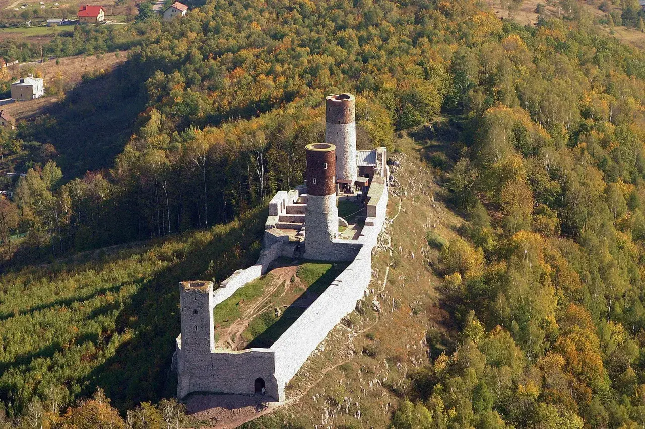 Ruiny zamku w Chęcinach na tle jesiennego lasu. Sprawdź chęciny zamek cennik, by zaplanować wizytę.