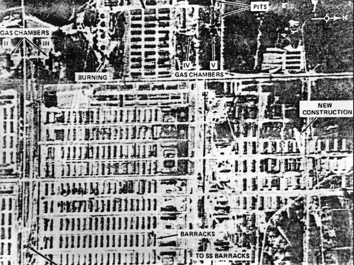 Zdjęcie lotnicze obozu Auschwitz. Widoczne baraki, komory gazowe, doły, nowe budowy i płonące obiekty.