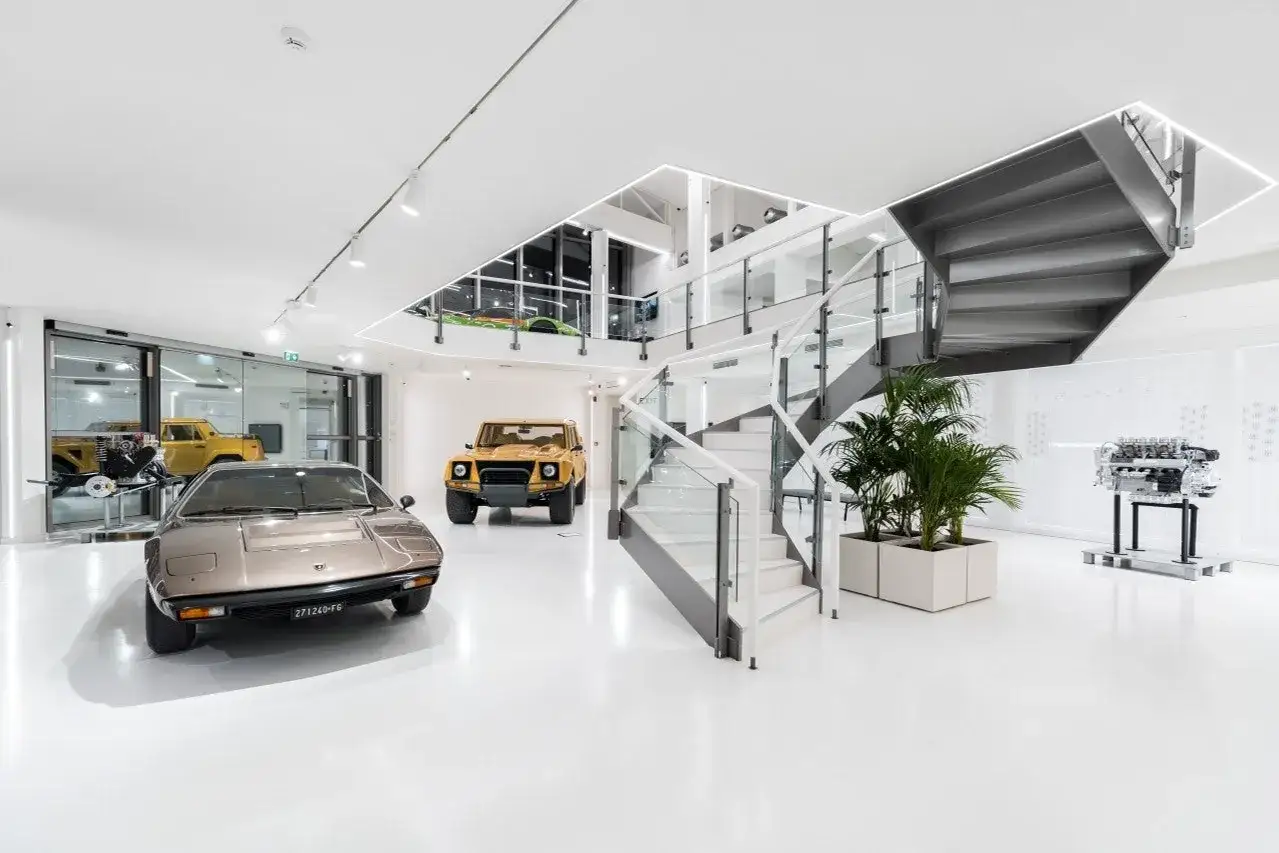 W muzeum Lamborghini można podziwiać klasyczne modele, w tym żółtego Jeepa i brązowy samochód sportowy.