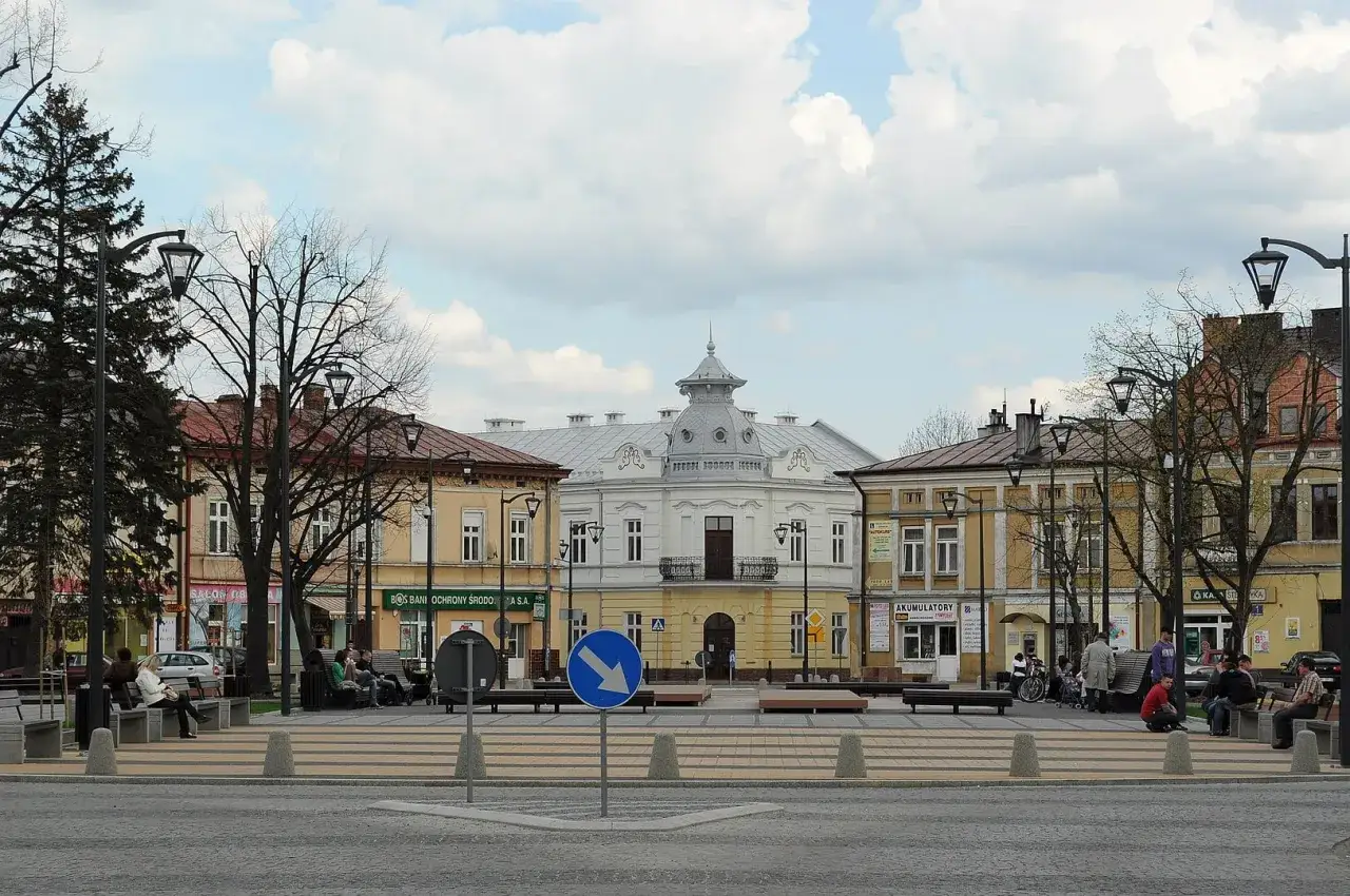 Rynek w Mielcu z kamienicami i ludźmi odpoczywającymi na ławkach. Idealne miejsce na mielec atrakcje na weekend.